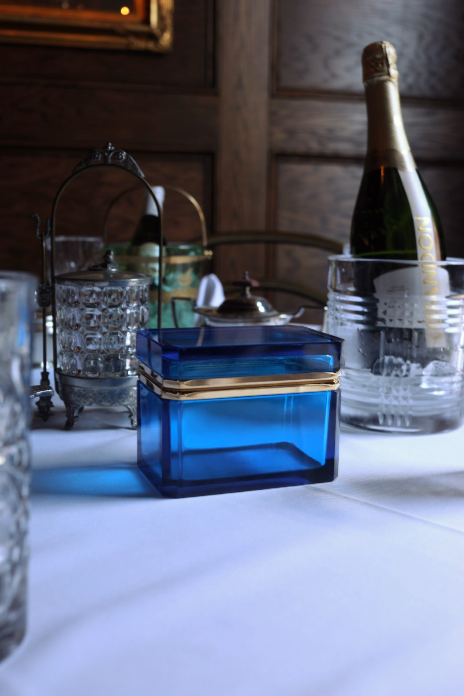 Murano sapphire-cobalt glass box styled on a bar cart with champagne bottle and vintage barware