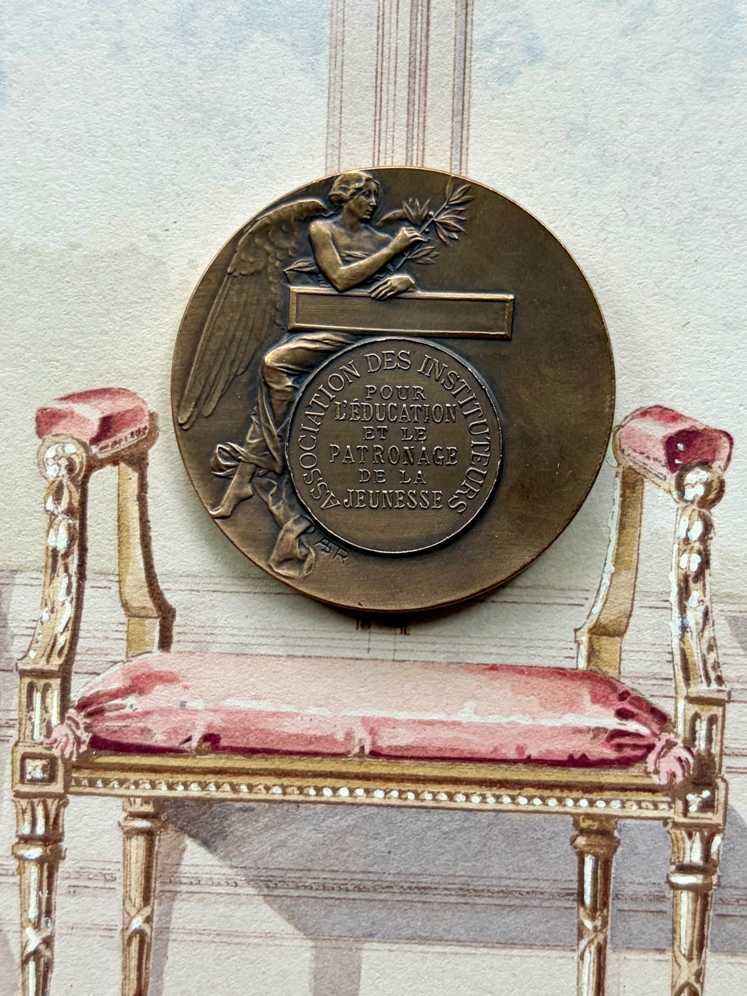 Reverse of the bronze medal with an allegorical angel figure and French inscription