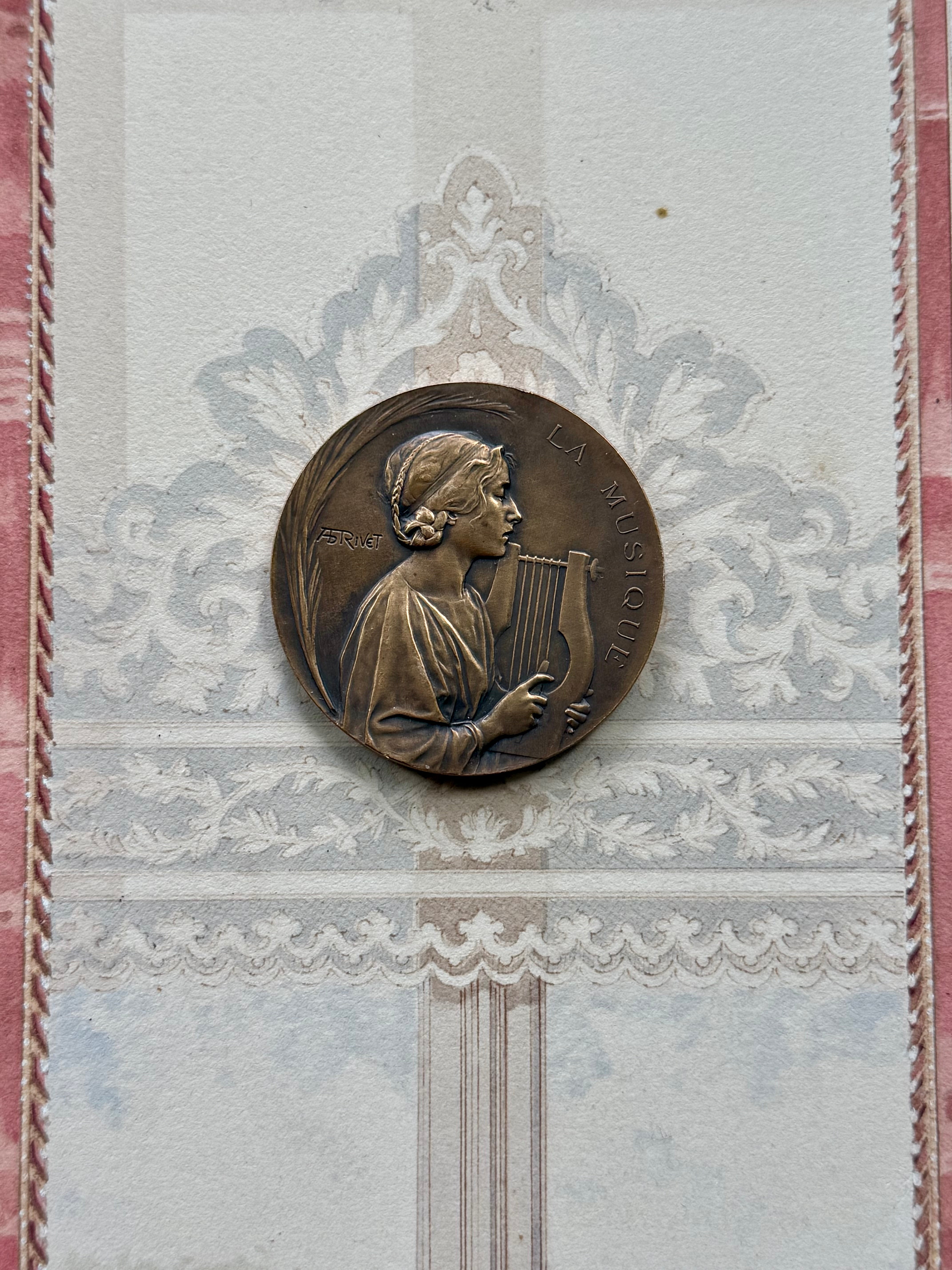 Close-up of the bronze medal inscribed LA MUSIQUE with warm honey patina